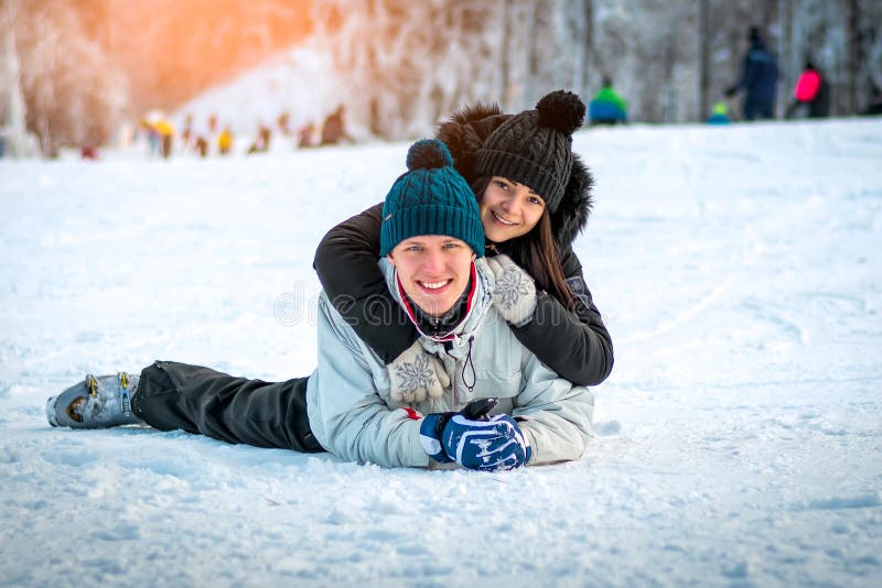 Pares felizes que encontram-se na neve imagem de stock Pares felizes que encontram-se na neve imagem de stock