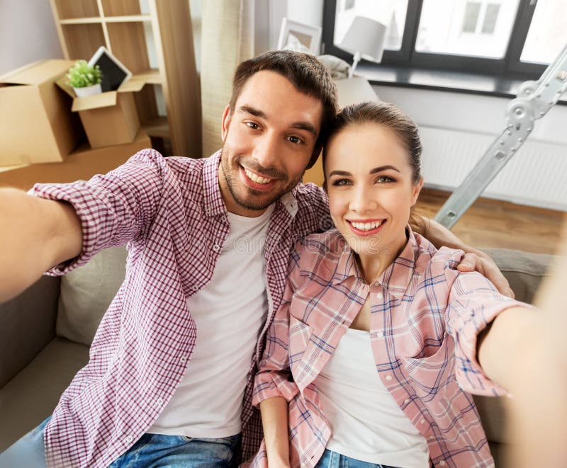 Pares felizes que tomam o selfie na casa nova foto de stock Pares felizes que tomam o selfie na casa nova foto de stock
