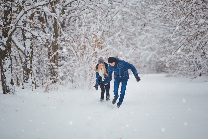 Pares felizes que têm o divertimento fora no parque da neve Férias do inverno foto de stock Pares felizes que têm o divertimento fora no parque da neve Férias do inverno foto de stock