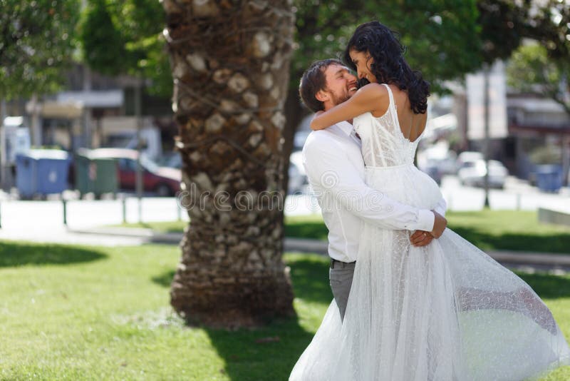 Pares hermosos de la boda que abrazan en parque público en Grecia, mirando uno a, en amor Amor en concepto del aire imagen de archivo libre de regalías Pares hermosos de la boda que abrazan en parque público en Grecia, mirando uno a, en amor Amor en concepto del aire imagen de archivo libre de regalías