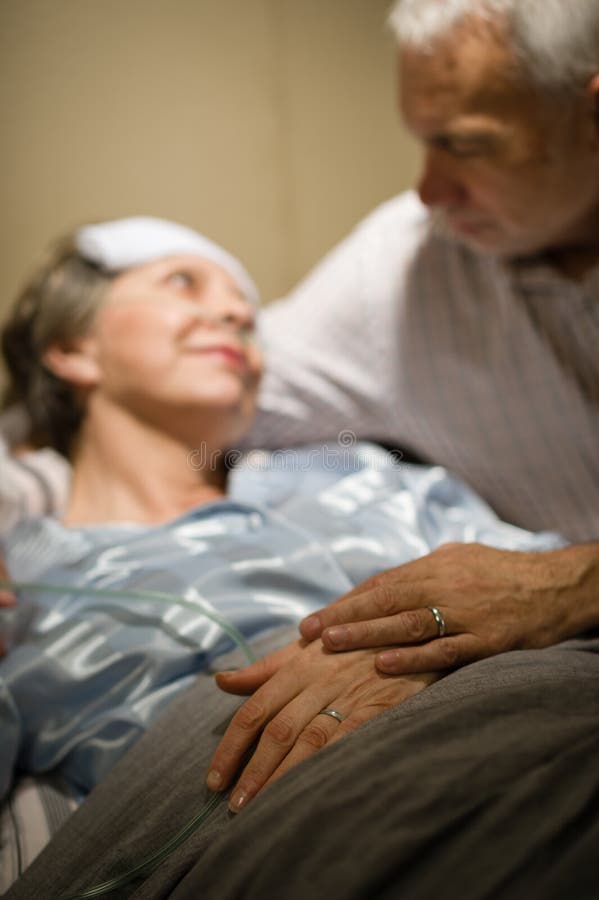 Pares idosos que guardaram as mãos na divisão da clínica imagem de stock Pares idosos que guardaram as mãos na divisão da clínica imagem de stock