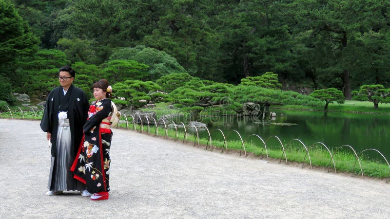 Pares japoneses de la boda en Ritsurin Koen Garden Takamatsu Japan fotografía de archivo Pares japoneses de la boda en Ritsurin Koen Garden Takamatsu Japan fotografía de archivo