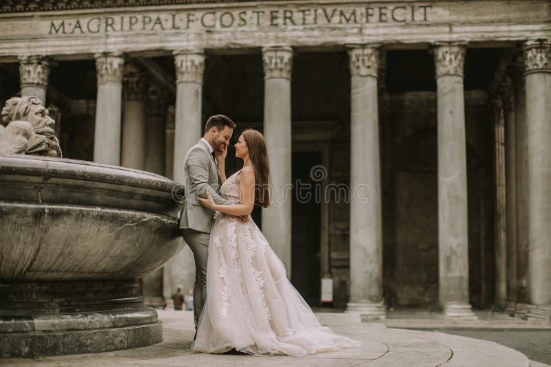 Pares jovenes de la boda por el panteón en Roma, Italia