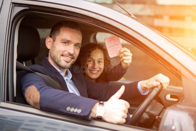 Pares jovenes del hombre de negocios en su coche a estrenar fotos de archivo Pares jovenes del hombre de negocios en su coche a estrenar fotos de archivo