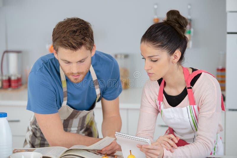 Pares jovenes felices del retrato que cocinan junto en cocina imagen de archivo libre de regalías Pares jovenes felices del retrato que cocinan junto en cocina imagen de archivo libre de regalías