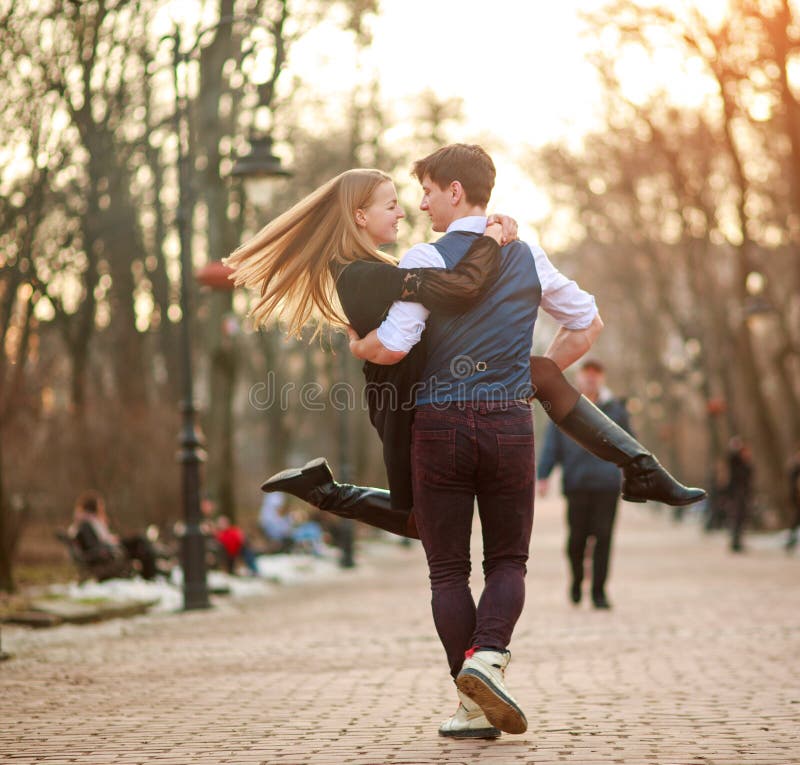 Pares jovenes felices en los recienes casados del amor alegre que se divierten en parque de la ciudad foto de archivo Pares jovenes felices en los recienes casados del amor alegre que se divierten en parque de la ciudad foto de archivo
