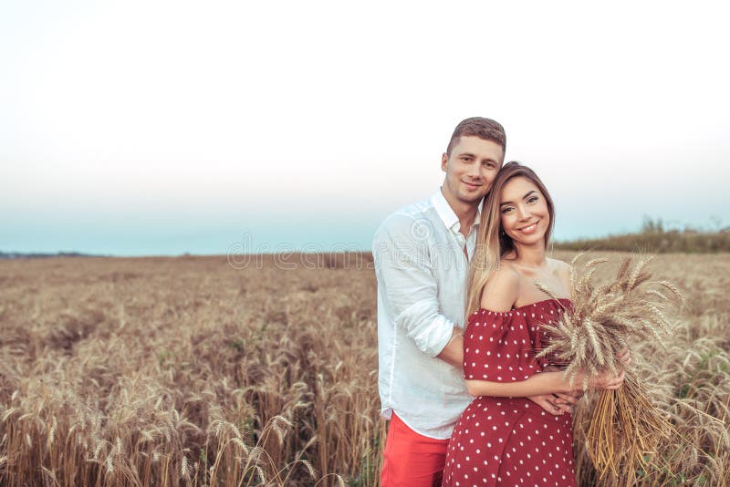 Pares jovenes hermosos, campo de trigo del verano del abrazo de la mujer del hombre Oídos de las manos del trigo Concepto de amor fotos de archivo libres de regalías Pares jovenes hermosos, campo de trigo del verano del abrazo de la mujer del hombre Oídos de las manos del trigo Concepto de amor fotos de archivo libres de regalías