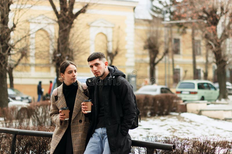 Pares jovenes que disfrutan del coffe al aire libre en el centro de ciudad imagen de archivo libre de regalías Pares jovenes que disfrutan del coffe al aire libre en el centro de ciudad imagen de archivo libre de regalías
