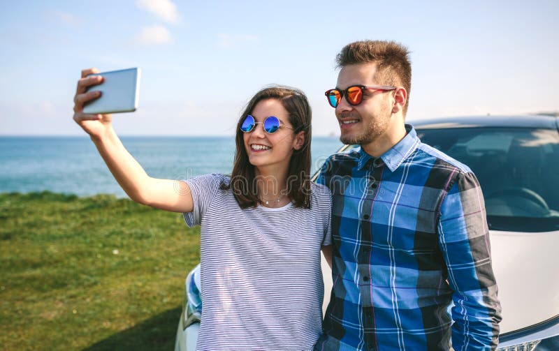Pares jovenes que hacen un selfie en el coche imagen de archivo libre de regalías Pares jovenes que hacen un selfie en el coche imagen de archivo libre de regalías