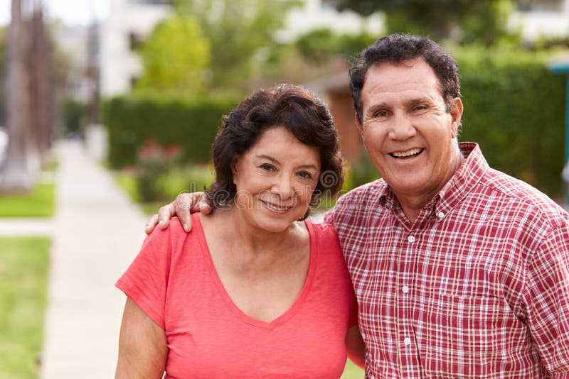 Pares latino-americanos superiores que andam ao longo do passeio junto fotografia de stock royalty free Pares latino-americanos superiores que andam ao longo do passeio junto fotografia de stock royalty free