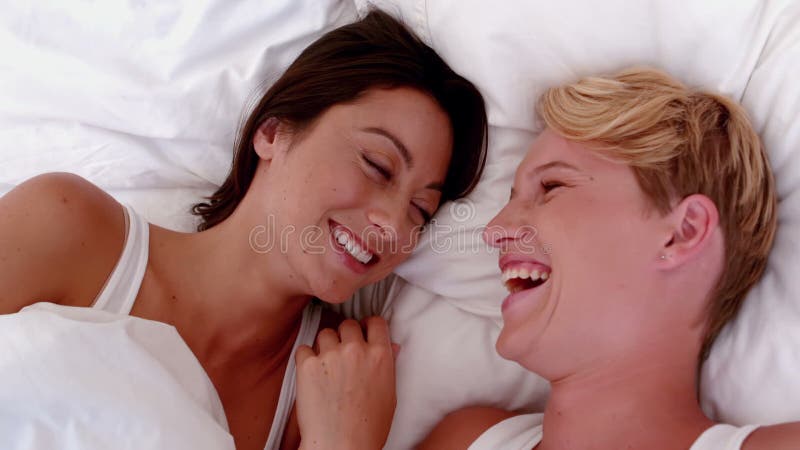 Pares lesbianos que ríen en cama almacen de metraje de vídeo