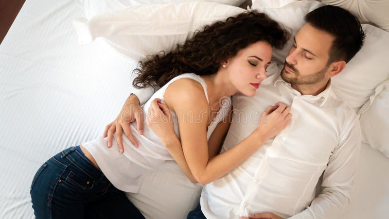 Pares lindos jovenes que mienten junto en cama imagen de archivo libre de regalías Pares lindos jovenes que mienten junto en cama imagen de archivo libre de regalías