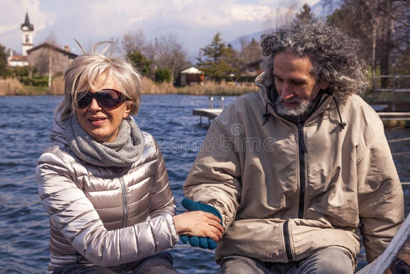 Pares maduros hermosos que se divierten que se sienta en un barco fotografía de archivo libre de regalías Pares maduros hermosos que se divierten que se sienta en un barco fotografía de archivo libre de regalías