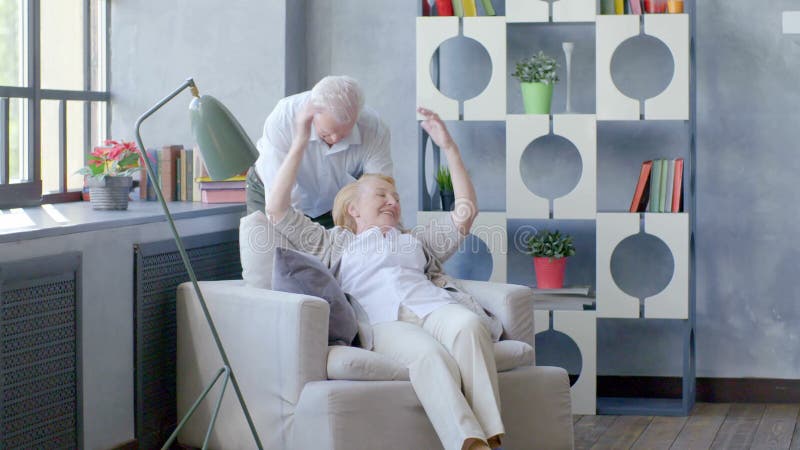 Pares mayores cariñosos y felices en un apartamento moderno El marido besa a su esposa