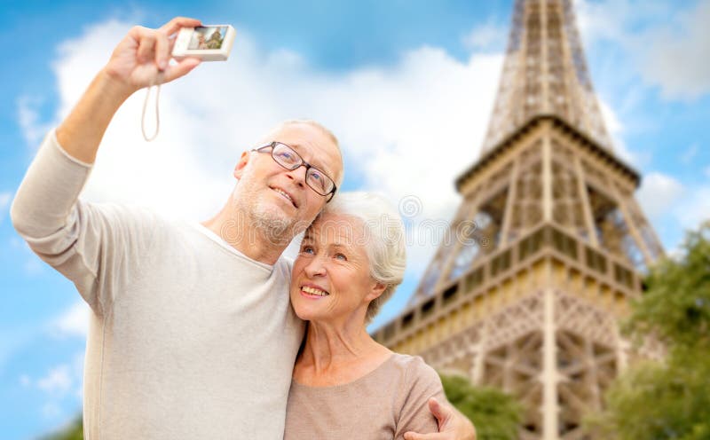 Pares mayores con la cámara sobre torre Eiffel imagenes de archivo
