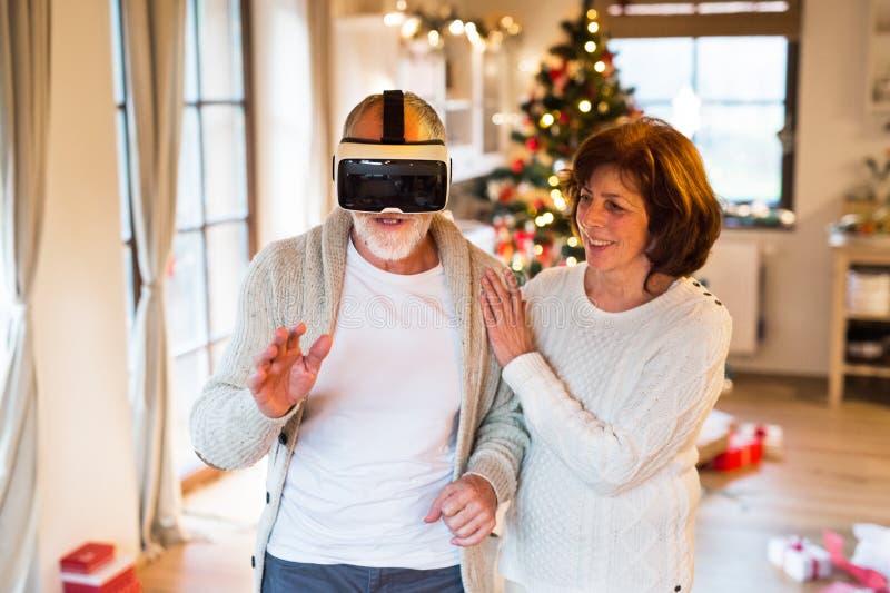 Pares mayores delante del árbol de navidad con las gafas de VR fotografía de archivo Pares mayores delante del árbol de navidad con las gafas de VR fotografía de archivo