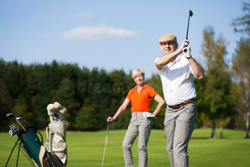 Pares mayores que juegan a golf foto de archivo libre de regalías Pares mayores que juegan a golf foto de archivo libre de regalías