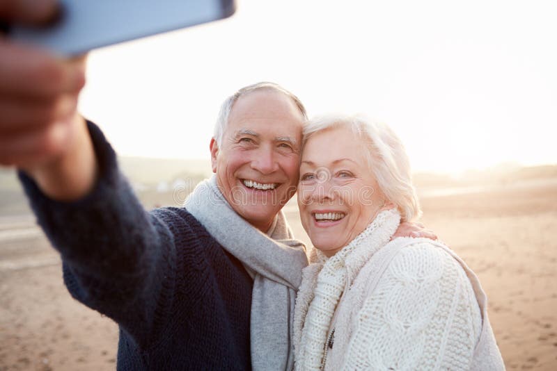 Pares mayores que se colocan en la playa que toma Selfie fotografía de archivo libre de regalías