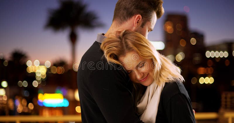 Pares modernos doces que abraçam fora na noite foto de stock Pares modernos doces que abraçam fora na noite foto de stock