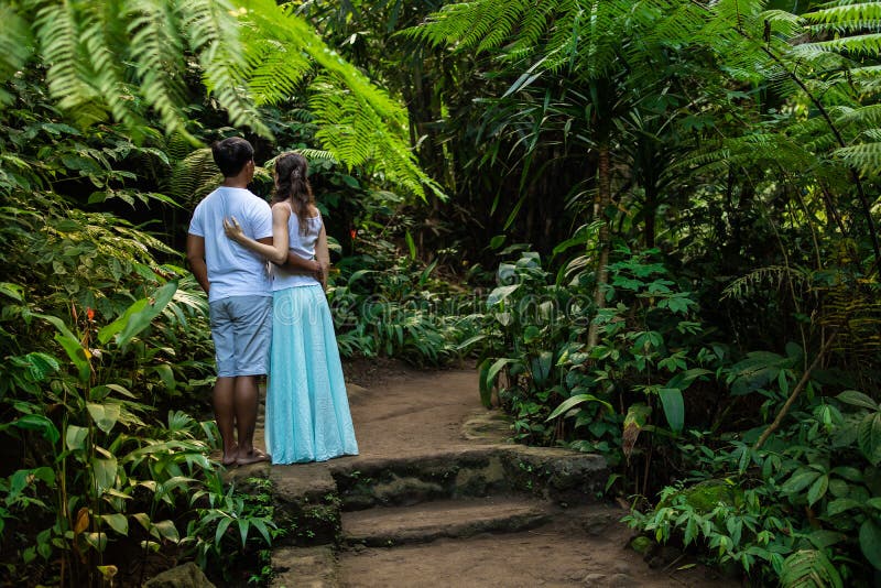 Pares multirraciales que abrazan en rastro que camina en pares jovenes de la raza mixta del bosque tropical de vacaciones en Asia imágenes de archivo libres de regalías Pares multirraciales que abrazan en rastro que camina en pares jovenes de la raza mixta del bosque tropical de vacaciones en Asia imágenes de archivo libres de regalías