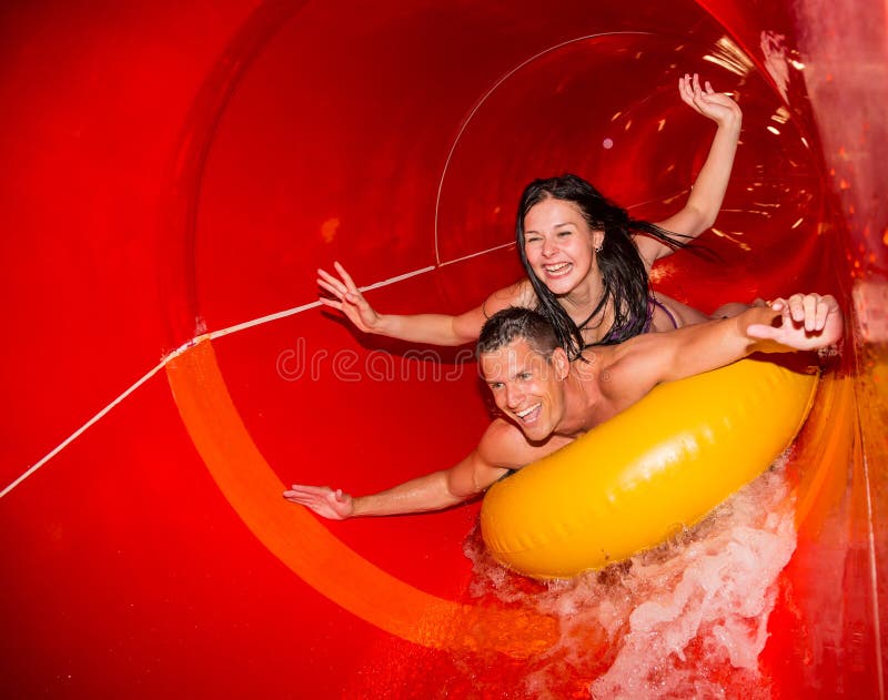 Pares na corrediça de água na piscina pública imagens de stock royalty free Pares na corrediça de água na piscina pública imagens de stock royalty free