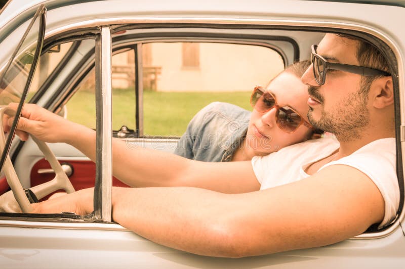 Couple in love during honeymoon vintage car trip - Hipster lifestyle traveling around the world with classic car - Warm retro filtered look. Couple in love during honeymoon vintage car trip - Hipster lifestyle traveling around the world with classic car - Warm retro filtered look