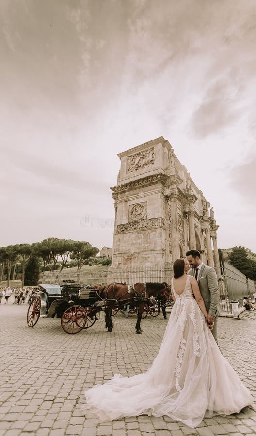 Pares novos do casamento pelo arco de Constantim em Roma foto de stock royalty free Pares novos do casamento pelo arco de Constantim em Roma foto de stock royalty free
