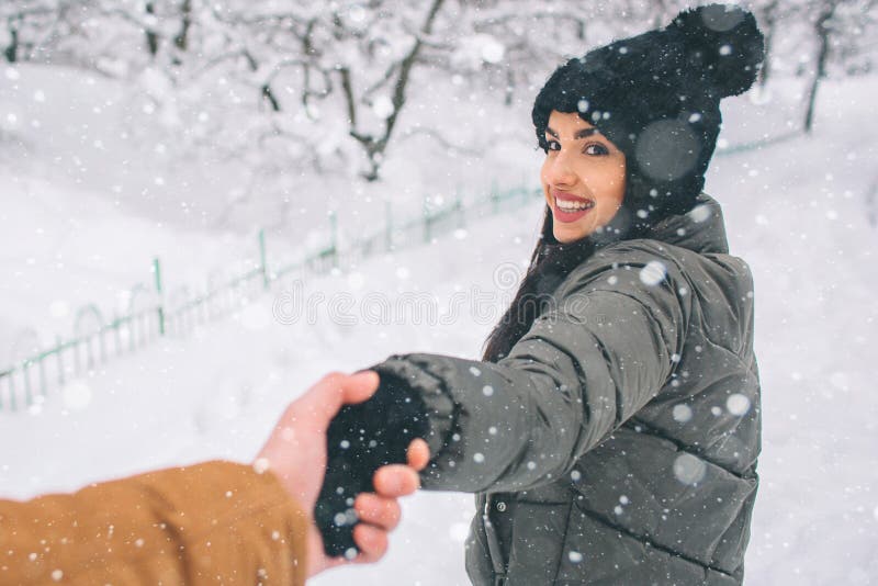 Pares novos felizes no inverno Família ao ar livre homem e mulher que olham ascendentes e riso Amor, divertimento, estação e povo foto de stock royalty free Pares novos felizes no inverno Família ao ar livre homem e mulher que olham ascendentes e riso Amor, divertimento, estação e povo foto de stock royalty free