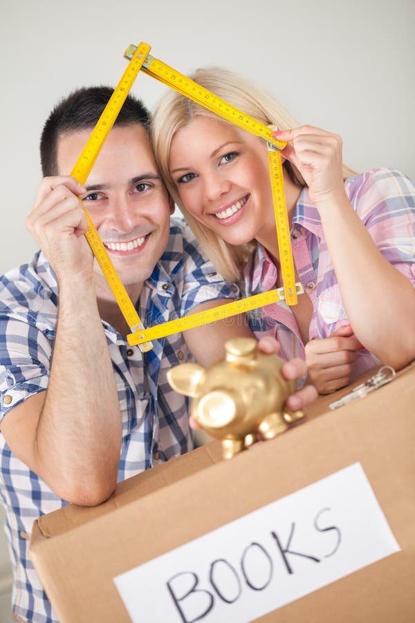 Pares novos que compram a casa nova fotografia de stock Pares novos que compram a casa nova fotografia de stock