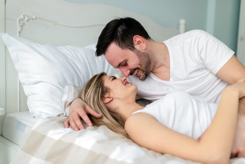 Pares novos que têm o tempo romântico no quarto foto de stock Pares novos que têm o tempo romântico no quarto foto de stock