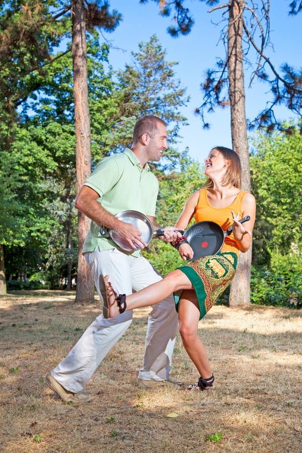 Pares novos que têm um divertimento na floresta foto de stock Pares novos que têm um divertimento na floresta foto de stock