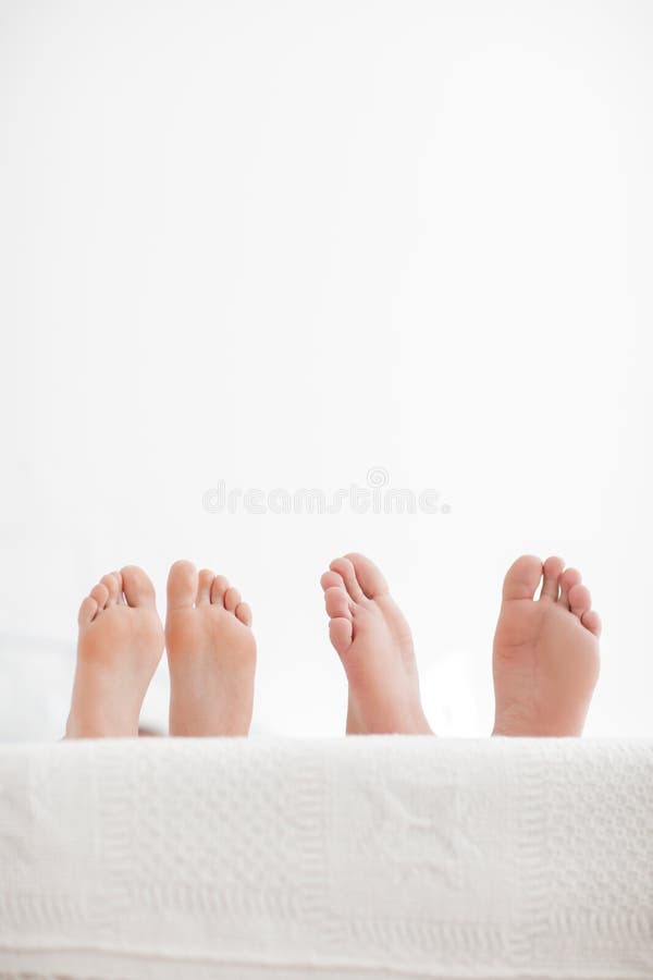 Pares novos sensuais junto na cama Pares felizes no quarto em um fundo branco foto de stock Pares novos sensuais junto na cama Pares felizes no quarto em um fundo branco foto de stock