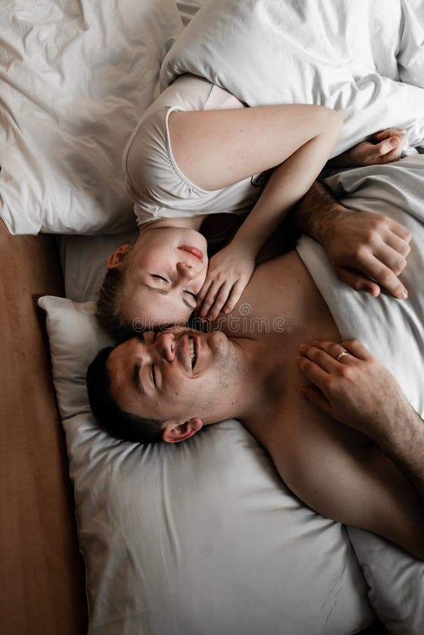 Pares o familia jovenes felices hermosos que despiertan junto en cama fotografía de archivo Pares o familia jovenes felices hermosos que despiertan junto en cama fotografía de archivo
