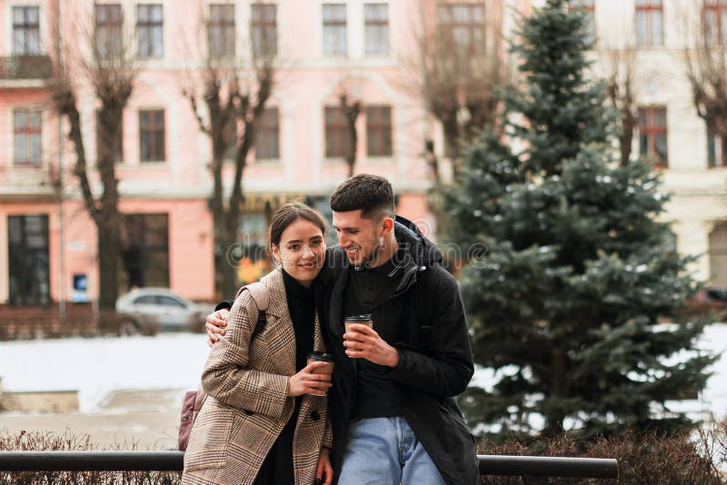 Pares positivos que descansan después del paseo, coffe para llevar de la bebida fotos de archivo libres de regalías Pares positivos que descansan después del paseo, coffe para llevar de la bebida fotos de archivo libres de regalías