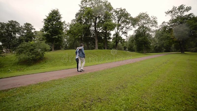 Pares preciosos jovenes que caminan en un parque en verano El fechar romántico o lovestory