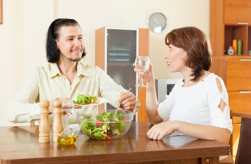 Pares que almuerzan con las verduras en hogar imagen de archivo Pares que almuerzan con las verduras en hogar imagen de archivo