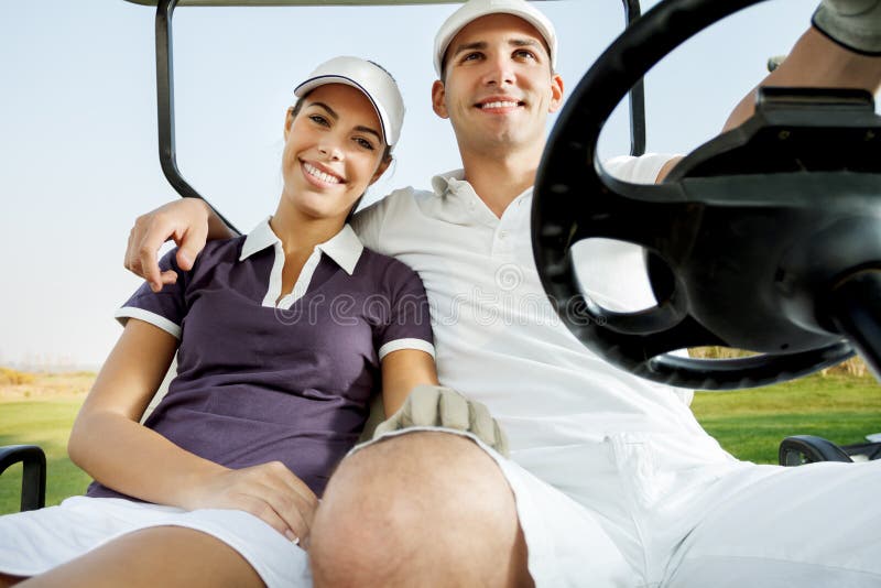 Pares que apreciam um jogo do golfe imagens de stock Pares que apreciam um jogo do golfe imagens de stock
