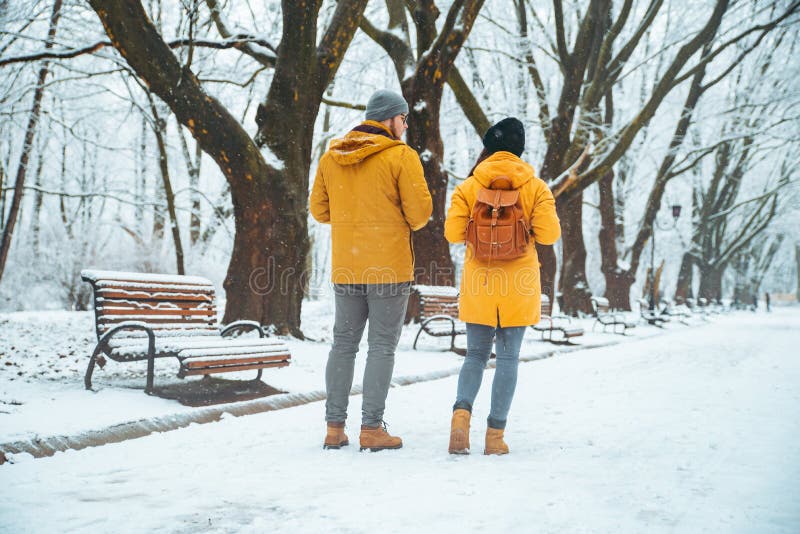 Pares que caminan por la socialización que habla nevada del parque de la ciudad fecha romántica en invierno fotos de archivo Pares que caminan por la socialización que habla nevada del parque de la ciudad fecha romántica en invierno fotos de archivo