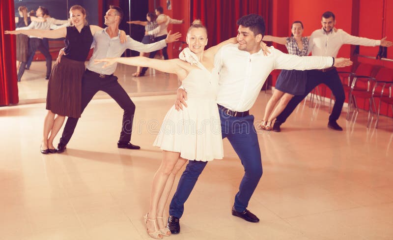 Pares que disfrutan de danzas del latín imágenes de archivo libres de regalías Pares que disfrutan de danzas del latín imágenes de archivo libres de regalías