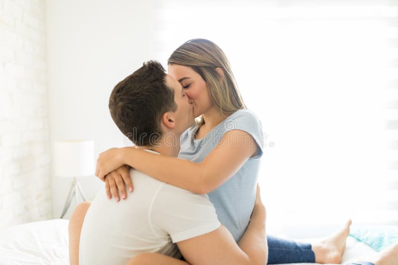 Pares que disfrutan de momentos que se besan románticos en cama foto de archivo libre de regalías Pares que disfrutan de momentos que se besan románticos en cama foto de archivo libre de regalías
