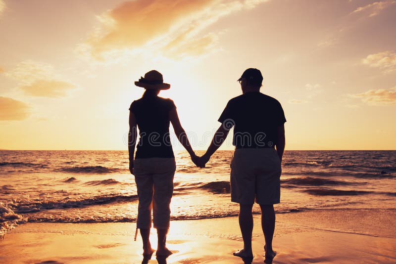Pares que disfrutan de puesta del sol en la playa foto de archivo libre de regalías Pares que disfrutan de puesta del sol en la playa foto de archivo libre de regalías