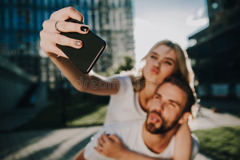 Pares que hacen muecas de la gente joven que hace la foto imagen de archivo Pares que hacen muecas de la gente joven que hace la foto imagen de archivo