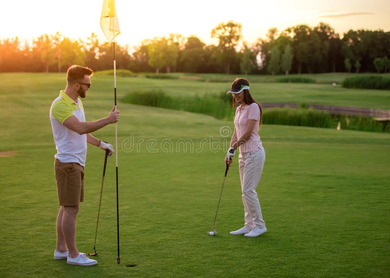 Pares que jogam o golfe fotografia de stock royalty free Pares que jogam o golfe fotografia de stock royalty free