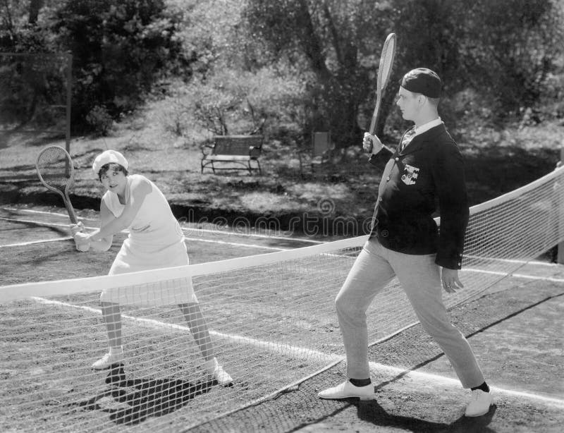 Couple playing tennis together (All persons depicted are no longer living and no estate exists. Supplier grants that there will be no model release issues.). Couple playing tennis together (All persons depicted are no longer living and no estate exists. Supplier grants that there will be no model release issues.)