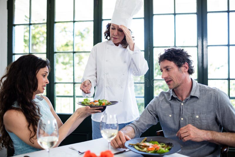 Pares que se quejan por la comida al cocinero imagenes de archivo Pares que se quejan por la comida al cocinero imagenes de archivo