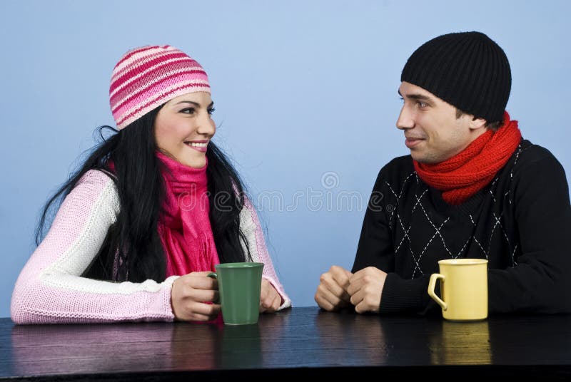 Young couple having a funny conversation and standing face to face at table enjoying a cup of tea together,check also my photos in this collection. Young couple having a funny conversation and standing face to face at table enjoying a cup of tea together,check also my photos in this collection