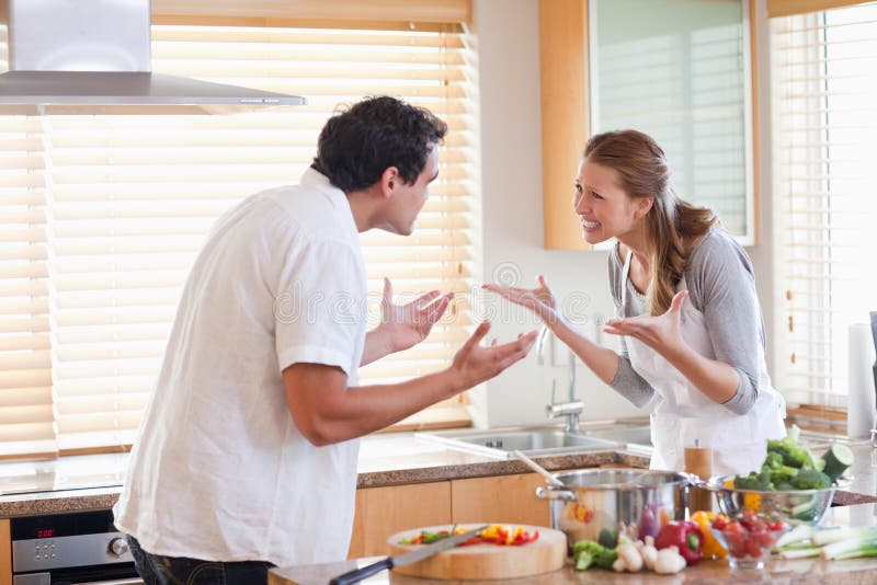 Pares que tienen una lucha en la cocina fotografía de archivo libre de regalías Pares que tienen una lucha en la cocina fotografía de archivo libre de regalías