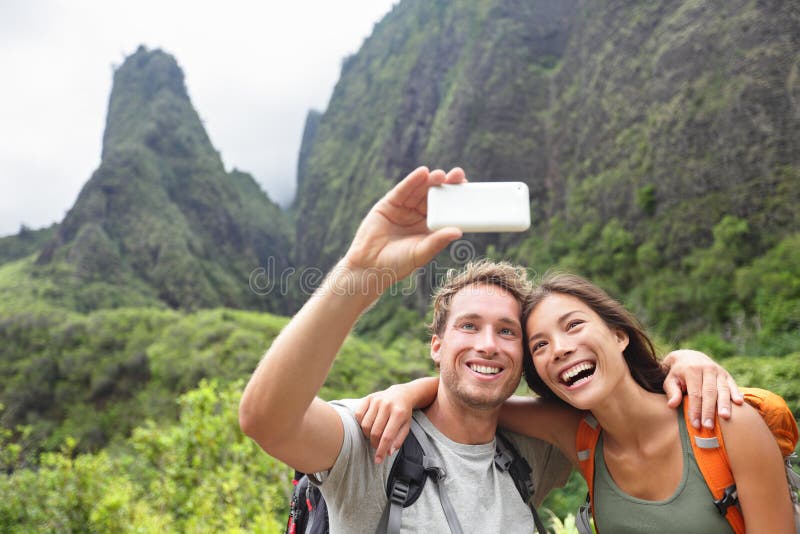 Pares que toman el selfie con el smartphone que camina Hawaii imagen de archivo