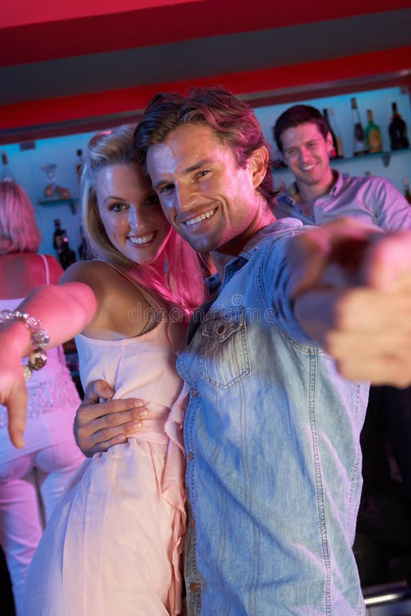 Couple Having Fun Smiling In Busy Bar. Couple Having Fun Smiling In Busy Bar