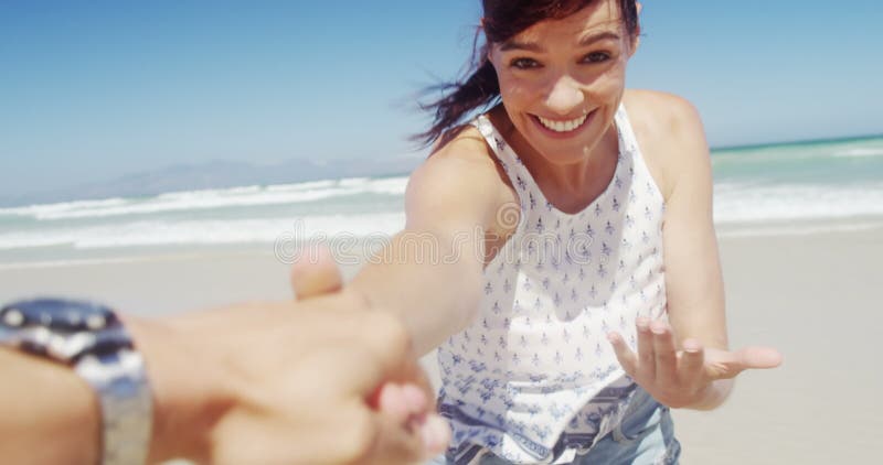 Pares que têm o divertimento na praia